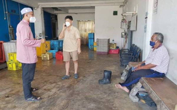 Asmirul Anuar (kiri) mendengar luahan hati pemborong ikan di Kuala Kedah pada Selasa.