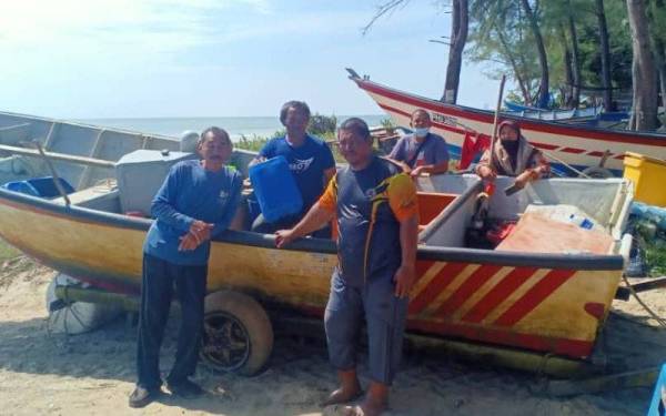 Nordin (kiri) bersama dua lagi nelayan yang diselamatkan setelah dilaporkan hilang selepas bot dinaiki mereka mengalami kerosakan ketika keluar memancing di perairan Kuala Kuantan pada Rabu. -Foto Maritim