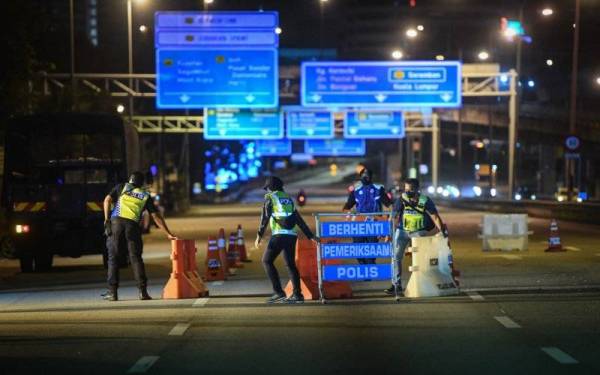 Anggota Polis Diraja Malaysia (PDRM) mengemas peralatan serta khemah setelah SJR ditamatkan 12 tengah malam Khamis di Lebuhraya Persekutuan. - Foto Bernama