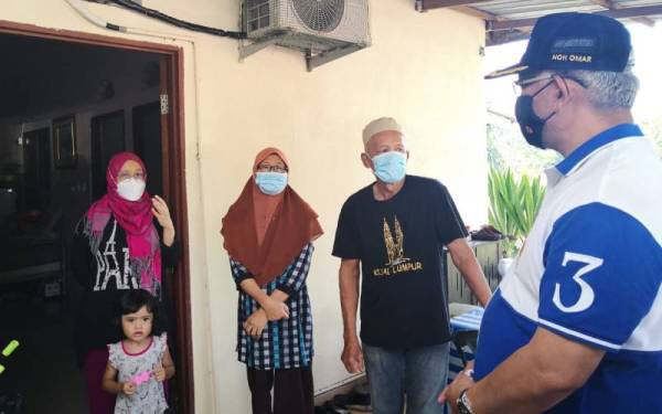 Noh (kanan) menemui Rabiatul Izzati (kiri) ketika melawat rumah ibu bapa wanita itu di Kampung Sungai Gulang-Gulang bagi penyampaian sumbangan Perkeso pada Jumaat.