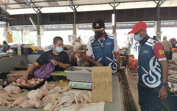 Rosol (tengah) meninjau harga ayam di Pasar Pekan Ajil di Hulu Terengganu pada Sabtu.