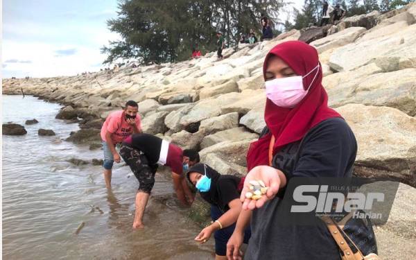 Seorang pengunjung, Siti Noor Yaacob, 36, (kanan) dari Kedai Lalat, Kota Bharu bersama suami, adik perempuan dan adik iparnya berusia antara 24 hingga 36 tahun yang sudah melengkapi dua dos vaksinasi Covid-19 pergi ke Pantai Nami itu untuk beridah sambil mencari remis.