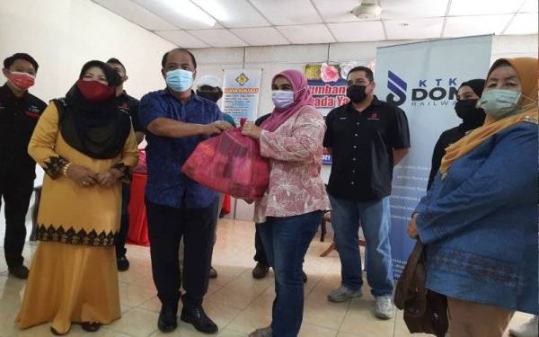 Wan Adnan (depan, dua dari kiri) menyampaikan sumbangan kepada wakil NGO di Balai Raya Balok, Kuantan pada Ahad.