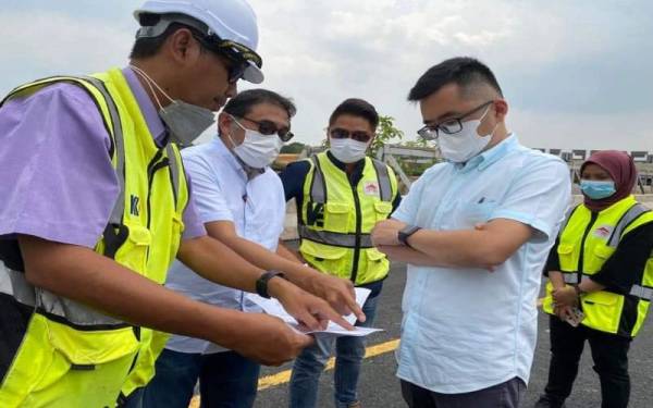 Wei Kiat (kanan) mendengar penerangan daripada kontraktor berkenaan penutupan sebahagian jalan di BCH bagi kerja naik taraf.