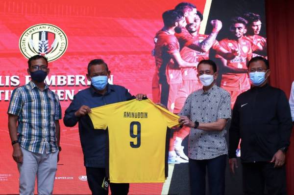 Tunku Syed Razman (dua, kanan) menyampaikan jersi kedua NSFC kepad Aminuddin pada Majlis Makan Malam Pasukan NSFC di sebuah hotel pada Selasa. - Foto Bernama