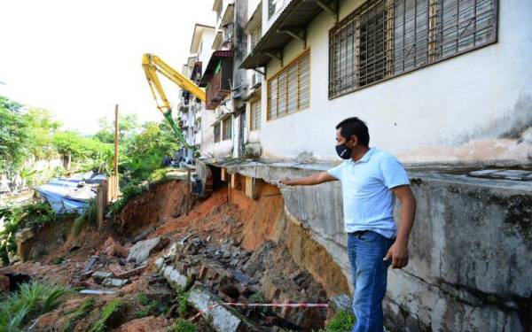 Fadzil menunjukkan lokasi runtuhan di sebuah blok Rumah Pangsa Sri Cempaka ketika ditemui pada Khamis. - Foto MOHD HALIM ABDUL WAHID