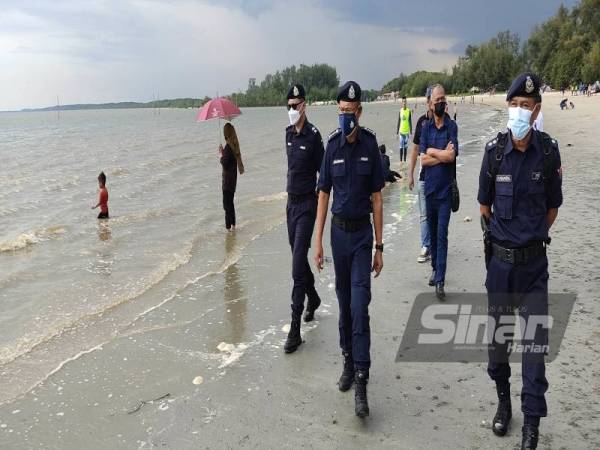 Arjunaidi (tengah) bersama pegawai dan anggotanya membuat pemantauan SOP di Pantai Bagan Lalang, Sepang pada Sabtu.