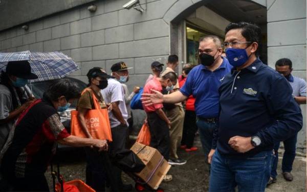 Jalaluddin beramah mesra bersama warga gelandangan pada sesi lawatan ke Program Edaran Pek Makanan kepada gelandangan ketika di Pusat Anjung Singgah Jalan Hang Lekiu pada Sabtu. - Foto Bernama