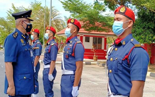 Mohammad Hamdan (kiri) memeriksa barisan kehormat anggota bomba semasa lawatan kerja ke JBPM Kelantan pada Ahad.