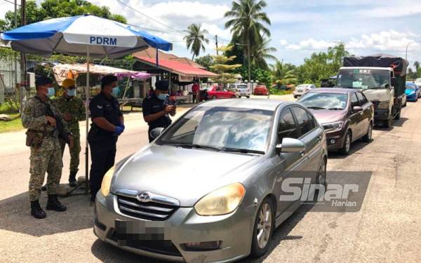 Shuhaimi Jusoh (empat, kiri) memeriksa kenderaan yang melalui Sekatan Jalan Raya (SJR) di Jambatan Pok Nik Loh di Jalan Padang Tembak, Kota Bharu, pada Ahad.