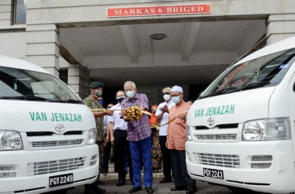 Mahdzir (tengah) secara simbolik memotong riben sambil disaksikan Khairul Anuar (kiri) dan Che Sa (kanan) bagi menerima sumbangan van jenazah daripada TNB di Sungai Petani pada Ahad.