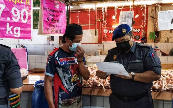 Shamsul Nizam (kanan) memeriksa harga ayam di Pasar Besar Alor Setar.