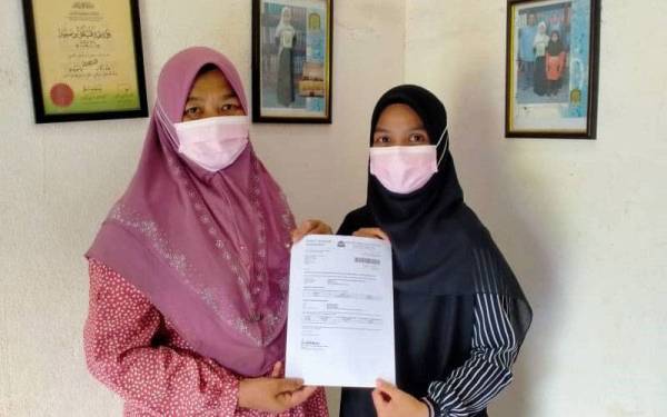 Nurul Mizani (kanan) bersama ibunya, Nur Sairah menunjukkan tawaran melanjutkan pengajian program Ijazah Sarjana Muda Bahasa Arab dan Komunikasi di USIM. 