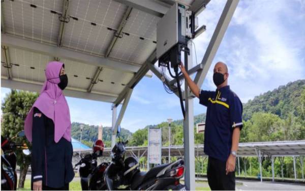 Dr Ermeey (kanan) bersama Dr Mazidah menunjukkan solar inverter yang dipasang pada bumbung letak kereta.