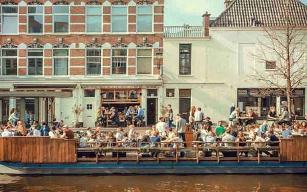 Kelihatan orang ramai makan di luar kafe di The Hague, Belanda. - Foto Getty Images