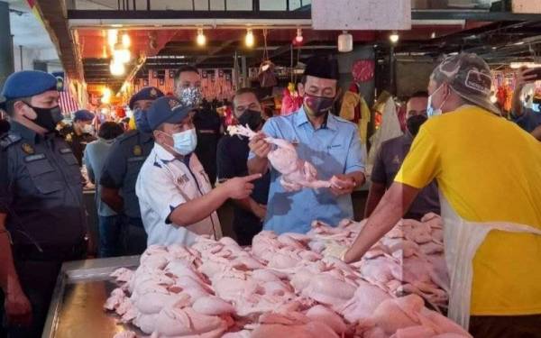 Pengarah KPDNHEP Selangor, Muhamad Zikril Azan Abdullah (dua dari kiri) dan Mohd Zawawi memantau harga ayam di Pasar Moden Seksyen 6, Shah Alam pada Selasa. - Foto Facebook KPDNHEP Selangor