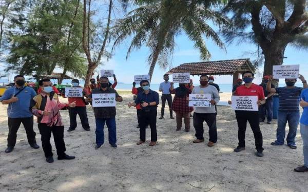 Sharudin dan pasukan pembersihannya mengangkat slogan Keluarga Malaysia cintakan kebersihan selepas mengadakan tinjauan di Pantai Kempadang pada Khamis.