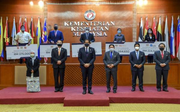 Khairy bersama penyampai sumbangan korporat Keluarga Malaysia di KKM hari ini. Turut sama KSU KKM, Datuk Mohd Shafiq Abdullah (depan; tiga, kanan) dan Ketua Pengarah Kesihatan, Tan Sri Dr Noor Hisham Abdullah (depan; dua, kiri).  Foto Bersama