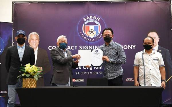 Bung Moktar bersama pengendali baharu Sabah FC, Kim Swee menunjukkan dokumen kontrak perjanjian yang ditandatangani dengan Sabah FC di Sabah International Convention Center (SICC) malam tadi. - Foto Bernama 