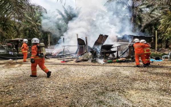 Anggota bomba memadamkan kebakaran rumah kongsi di Kampung Bukit Betong Kuala Lipis pada Sabtu. - Foto ihsan bomba