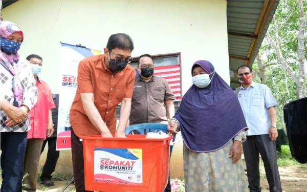 Zahidi merangkap Ahli Parlimen Padang Besar menyampaikan sumbangan kepada warga emas, Che Nah Musa,67, dari Kampung Kok Mak pada Program Komuniti Keluarga Malaysia di Masjid Othmaniah, Kok Mak pada Sabtu. - Foto Bernama 