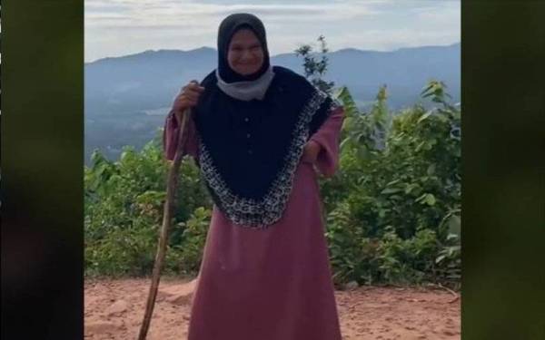  Wan Zaharah Wan Ismail tiba di puncak Bukit Panau di Tanah Merah bersama ahli keluarganya, disambut dengan tepukan dari pendaki lain.