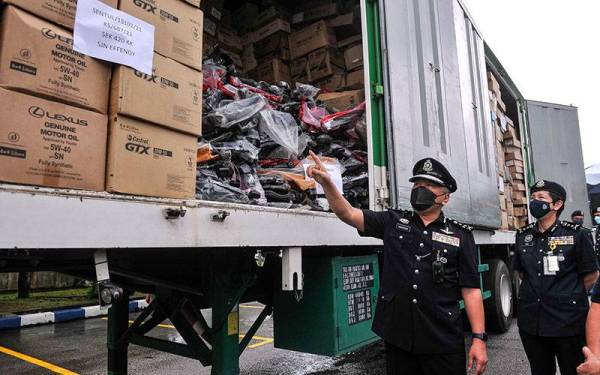 Mohd Kamarudin (dua, kanan) melihat barangan rampasan ketika sidang media mengenai tangkapan sindiket penipuan pembelian barangan tukar ganti kenderaan 'Fly By Night' di Balai Polis Jinjang pada Selasa. - Foto Bernama