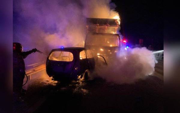 Anggota bomba melakukan pemadaman kebakaran melibatkan MPV dan lori ayam di Tapah. - Foto ihsan JBPM Perak