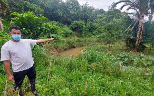 Mohamad Nasir menunjukkan keadaan sungai yang sempit didakwa akibat ditambak pihak tidak bertanggungjawab.