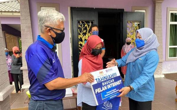 Menteri Pengajian Tinggi, Datuk Seri Dr Noraini Ahmad (kanan) menyampaikan sumbangan kepada Mahasiswi Universiti Awam (UA) yang memerlukan pada program Walkabout Sentuhan Kasih Mahasiswa@KPT Prihatin di sekitar daerah Batu Pahat pada Sabtu. - Foto Bernama