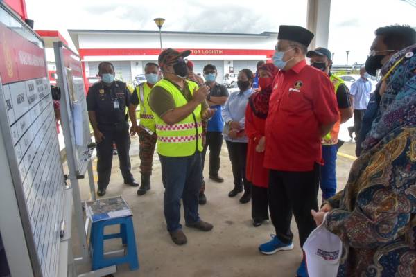 Shahidan mendengar penerangan mengenai kejadian banjir Kampung Rancha-Rancha daripada Pengarah JBPM Labuan Ismaidi Ismail (tiga, kiri) di PPS balai bomba Rancha-Rancha hari ini.  -Foto Bernama