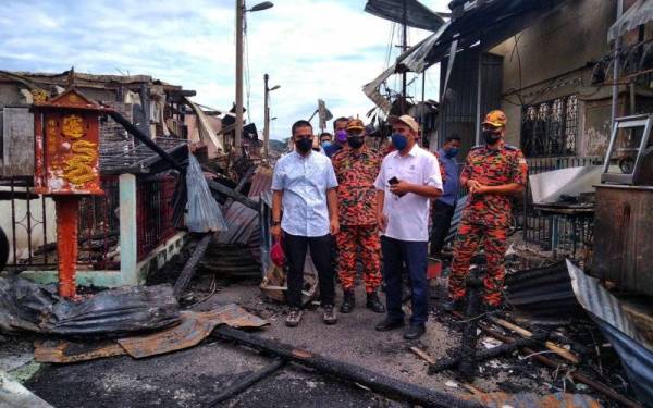 Wan Mohammad Zaidi (dua,kiri) mengiringi Abd Rahim (dua,kanan) bersama Mohd Zulkifli (kiri) ketika meninjau di lokasi kebakaran di Kampung Baru Karak pada Sabtu.