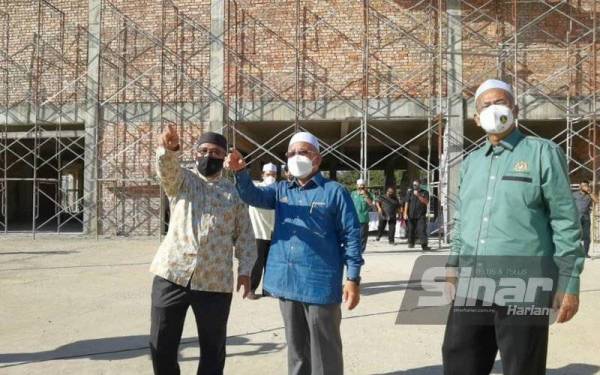 Tuan Ibrahim (tengah) ketika meninjau pembinaan Pasaraya Wakaf Ummah di Dungun pada Ahad.