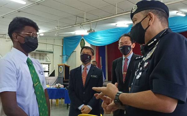 Pelajar Tingkatan 6, SMK St Michael Ipoh, S Vishu, 19, mendengar nasihat berkaitan pematuhan SOP disampaikan Mior Faridalathrash.