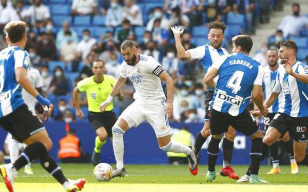 Penyerang Real Madrid, Karim Benzema cuba melepasi kawalan pemain Espanyol pada perlawanan berkenaan. - Foto liputan6.com