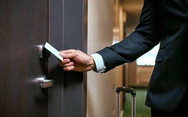 Businessman in hotel. Close-up of using keycard to open the door or scan keycard open door for chance