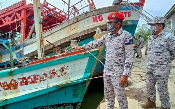 Mohd Zubil (kiri) bersama Syed Nor Adli mengadakan lawatan ke Pusat Tahanan Vesel Maritim Malaysia Kelantan di Tok Bali, Pasir Puteh pada Isnin.