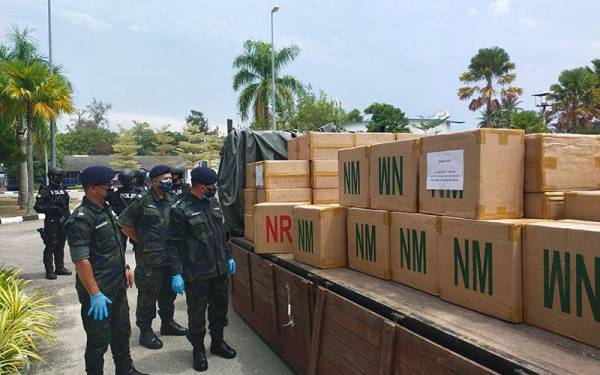 Hassan Basri (kanan) melihat rampasan rokok yang direkodkan di pekarangan Batalion 9 PGA, Gong Badak, Kuala Nerus pada Isnin.