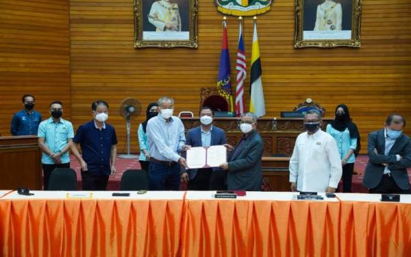 Rumaizi (tiga dari kanan) menerima dokumen MoU daripada wakil sebuah syarikat yang terbabit dalam cadangan pembinaan jalan utama Meru Raya - Klebang di Ipoh.