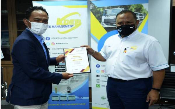 Ramli (kanan) menyampaikan sijil kepada wakil syarikat Mofiz Resources pada Majlis Penganugerahan Sijil ISO 9001:2015 kepada Subkontraktor Lantikan KDEBWM di sini.