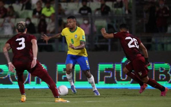 Penyerang Brazil, Gabriel Jesus, cuba melepasi kawalan pertahanan Venezuela pada aksi kelayakan berkenaan. - Foto EPA