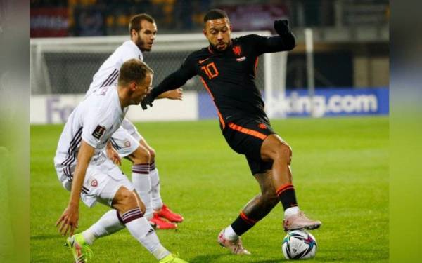 Penyerang Belanda, Memphis Depay (kanan), cuba melepasi kawalan pertahanan Latvia pada aksi kelayakan berkenaan. - Foto EPA