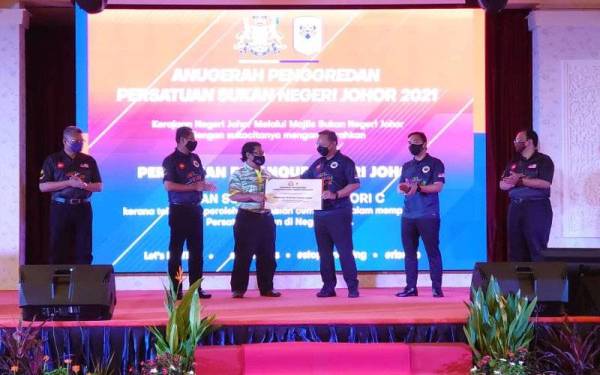 Hasni Mohammad (tiga kanan) menyerahkan sijil Anugerah Penggredan Persatuan Sukan Negeri Johor sempena pelancaran Hari Sukan Negara 2021 Peringkat Negeri Johor di Iskandar Puteri, pada Sabtu.