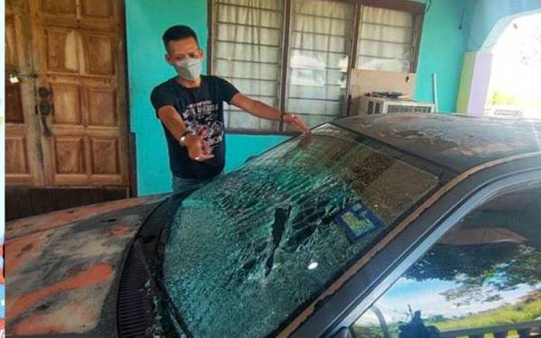 Mangsa yang berang bertindak menetak cermin sebuah kereta. - Gambar/ Astro AWANI