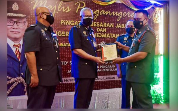 Mohammad Hamdan (dua dari kiri) menyampaikan sijil perkhidmatan cemerlang kepada anggota penerima, Azlan Talin (kanan) pada Majlis Penganugerahan Pingat Kebesaran Jabatan dan Anugerah Perkhidmatan Cemerlang Tahun 2020 JBPM Labuan, di sini hari ini. - Foto Bernama