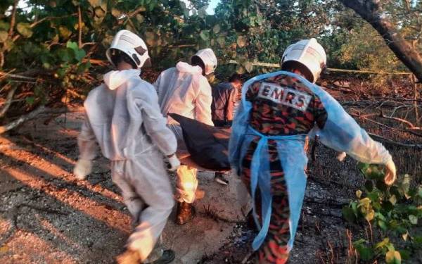 Anggota bomba mengangkat mayat lelaki warga asing yang ditemui di Pantai Rambah, Pontian pada Isnin.