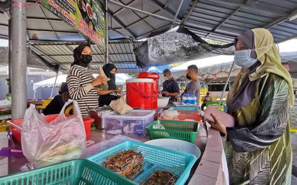 Pekerja Warung Tok Pelam yang beroperasi di Kuala Terengganu melayan pelanggan yang berkunjung di gerai berkenaan.