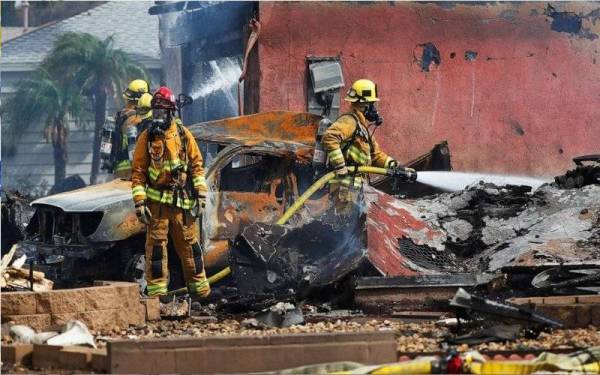 Gambar menunjukkan bangkai sebuah pesawat ringan yang hangus terbakar selepas terhempas kawasan kediaman dekat San Diego pada Isnin. - Foto San Diego Union-Tribune/Zuma Press