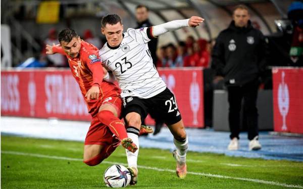 Pemain Jerman, Florian Wirtz (kanan) cuba melepasi asakan pertahanan Macedonia Utara, Stefan Askovski pada aksi kelayakan berkenaan. - Foto EPA