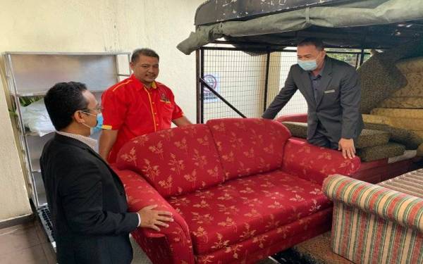 Amer (kanan) dan Shamsul (kiri) turut membantu menguruskan perpindahan sofa terpakai sumbangan Hotel The Grand Renai, Kota Bharu pada Selasa.